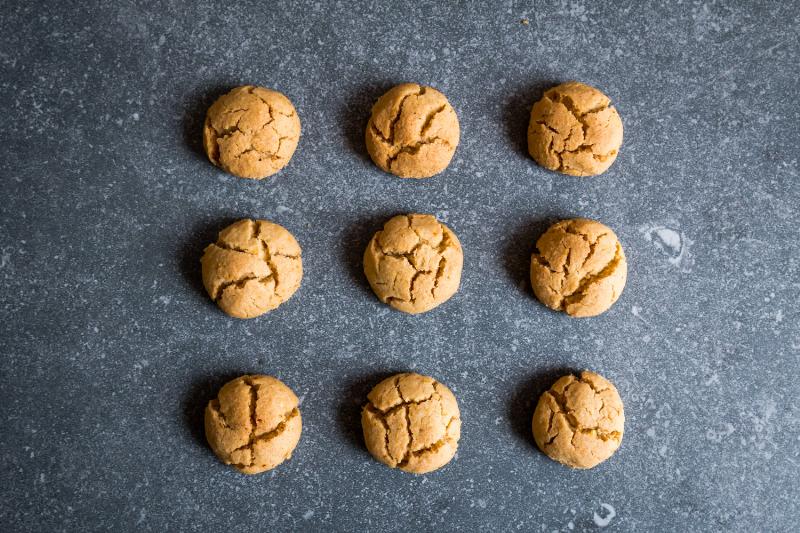 Cardamom cookies baking on a baking sheet in the oven.