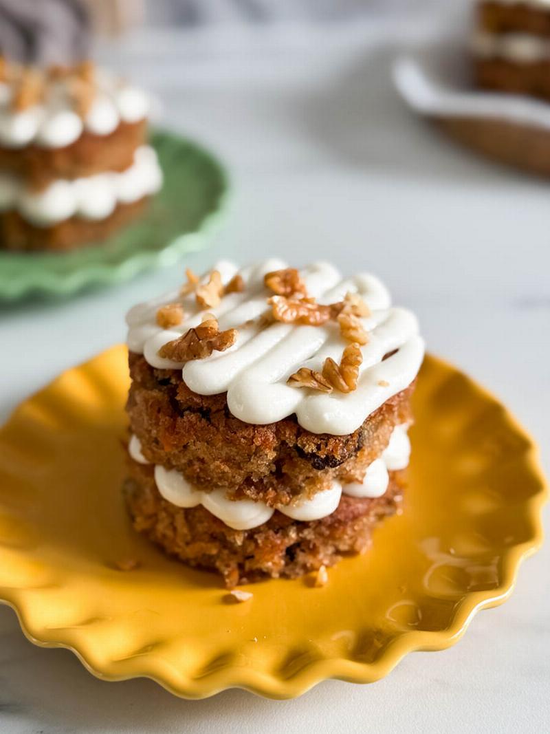 Close-up of a perfect carrot cake slice, showcasing moist crumb, cream cheese frosting, and visible carrot pieces.