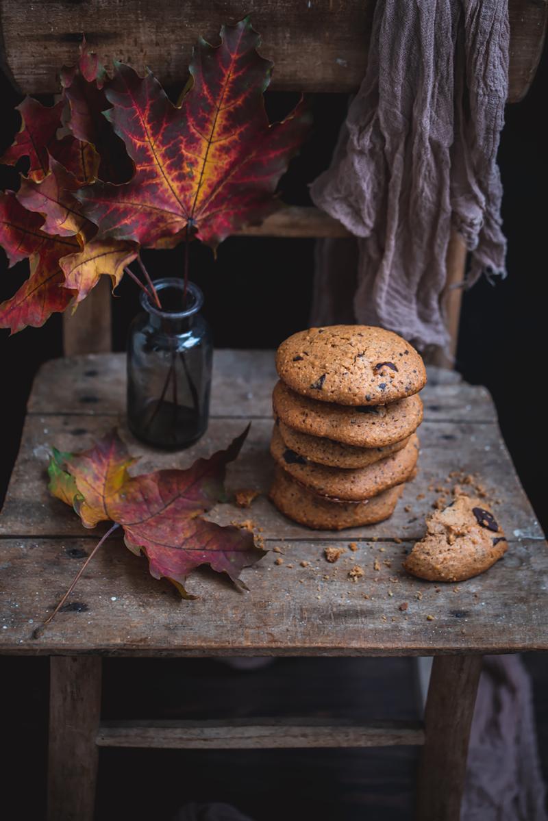 Ingredients for chocolate chip cookie dough arranged on a wooden surface.