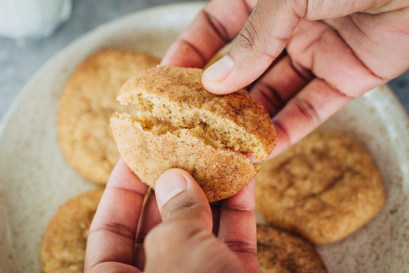 A close-up of snickerdoodle cookie dough with a small spoon of cream of tartar.