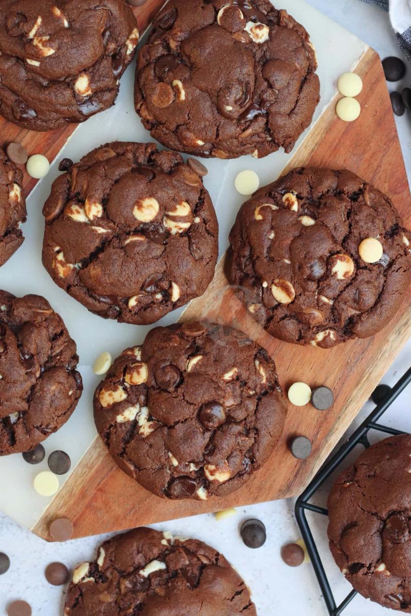 Various stages of baking crinkle cookies, from dough balls to finished cookies.