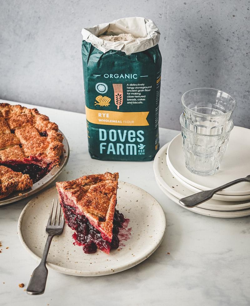 Blueberry pie with lattice crust, fresh blueberries, and baking tools