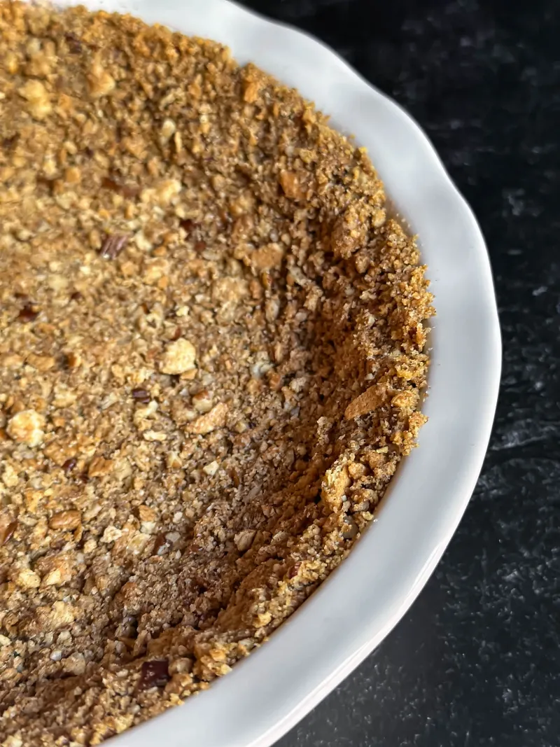 Preparing graham cracker crust for easy homemade cheesecake