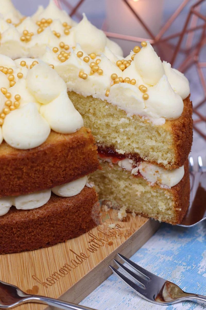 Frosting a two-layer vanilla cake with vanilla buttercream.