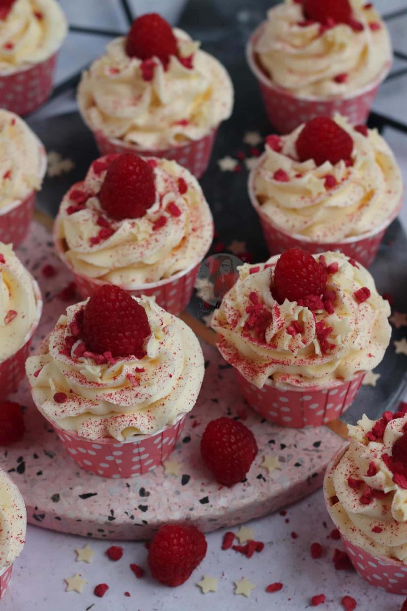 Gluten-free raspberry cupcakes with fresh raspberries on top.