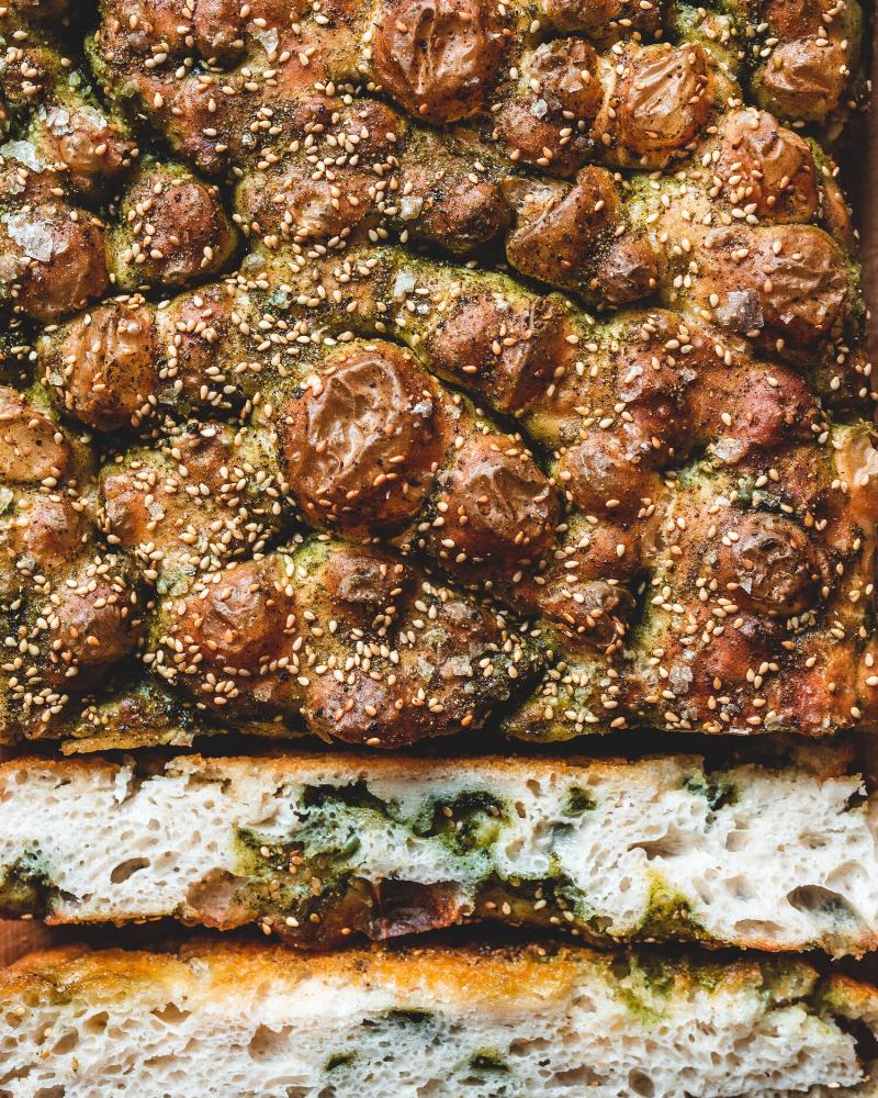 A loaf of bread with a golden crust baked in a cast iron skillet.