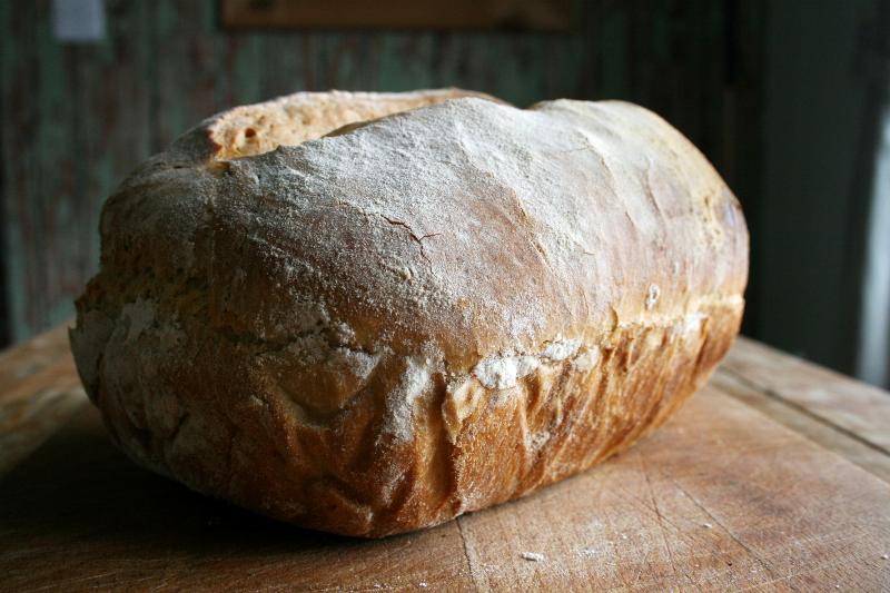 Kneading dough by hand on a lightly floured surface, a fundamental bread baking skill.