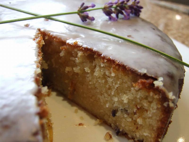 Frosted lavender cupcakes decorated with edible lavender buds and sprigs of fresh lavender.