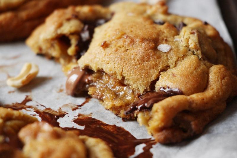 Close-up of a perfect chocolate chip cookie, showing the golden brown edges and melty chocolate chips.