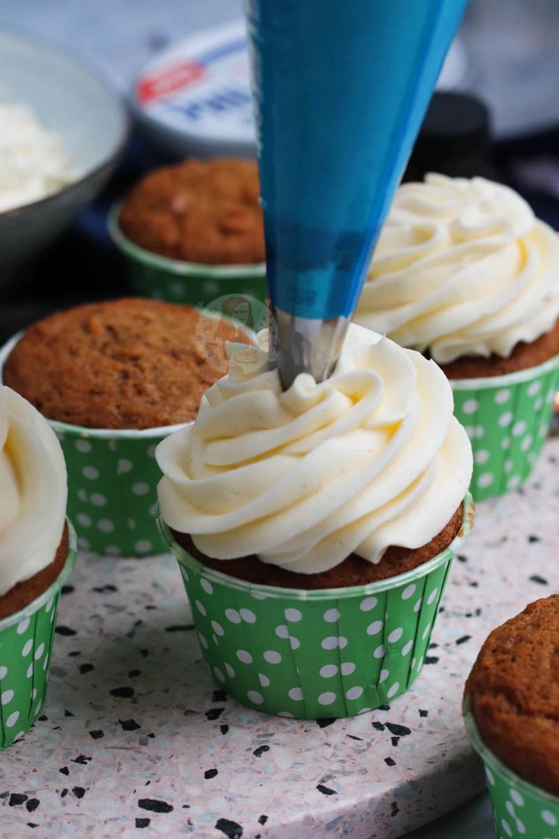 Several perfectly baked cupcakes, frosted and decorated, arranged on a cake stand.