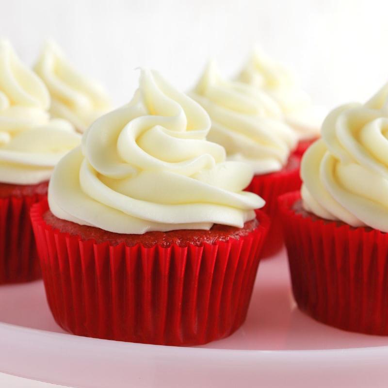 Red velvet cake batter in a mixing bowl, ready to be poured into cake pans.