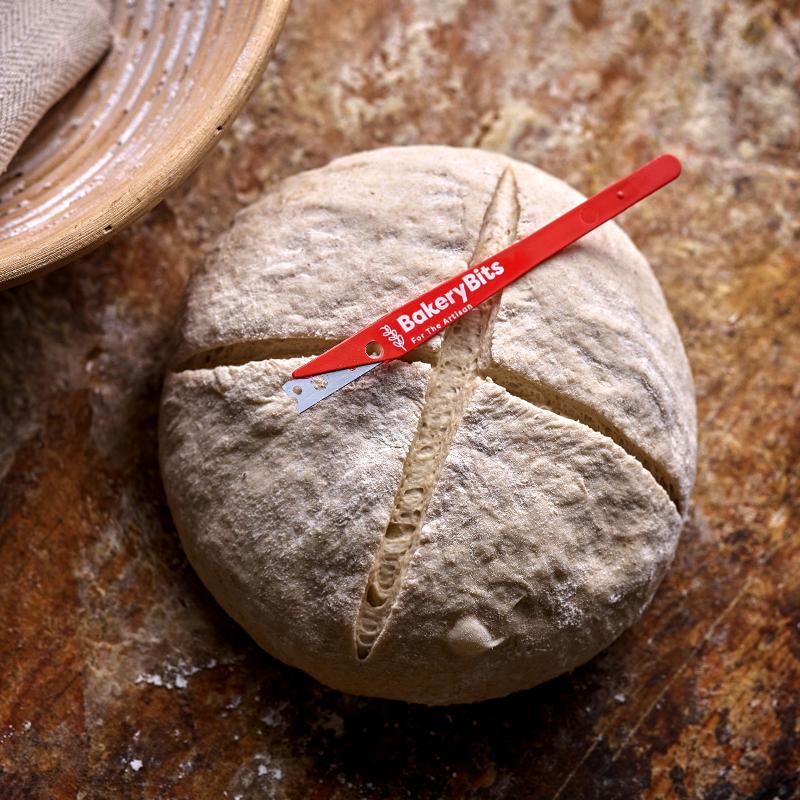 Scoring French bread dough with a lame.