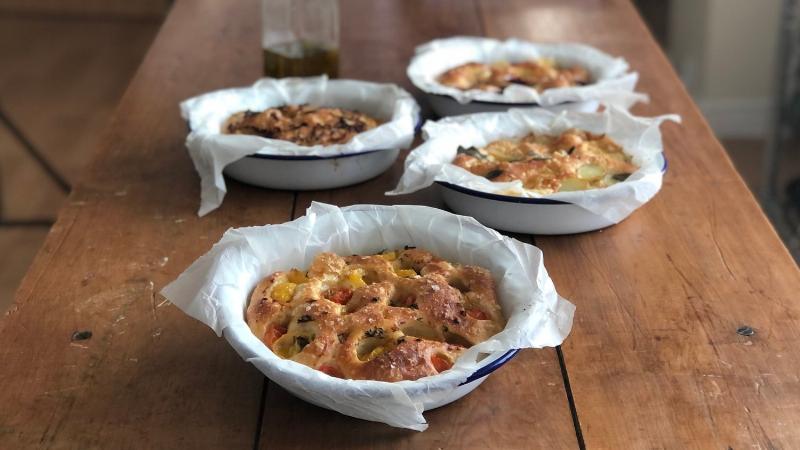 Various homemade focaccia recipes featuring different toppings like rosemary, sea salt, garlic, herbs, tomatoes, olives, cheese, and onions