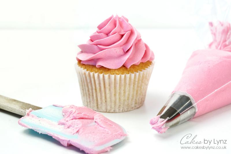 Piping swirls of chocolate buttercream frosting onto cupcakes using a piping bag and star tip.