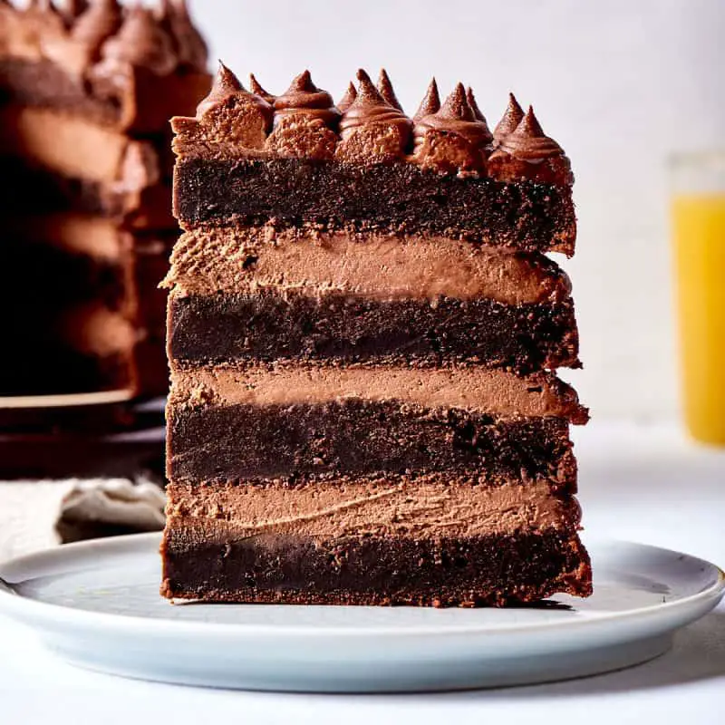 Rich keto chocolate cake slice with avocado frosting, dark and moist texture