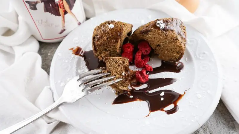 A decadent keto chocolate mug cake served warm in a blue microwave-safe mug, ready to eat